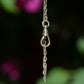 A closely cropped photo of the bracelet suspended and dangling, focusing on the dog clip clasp. 