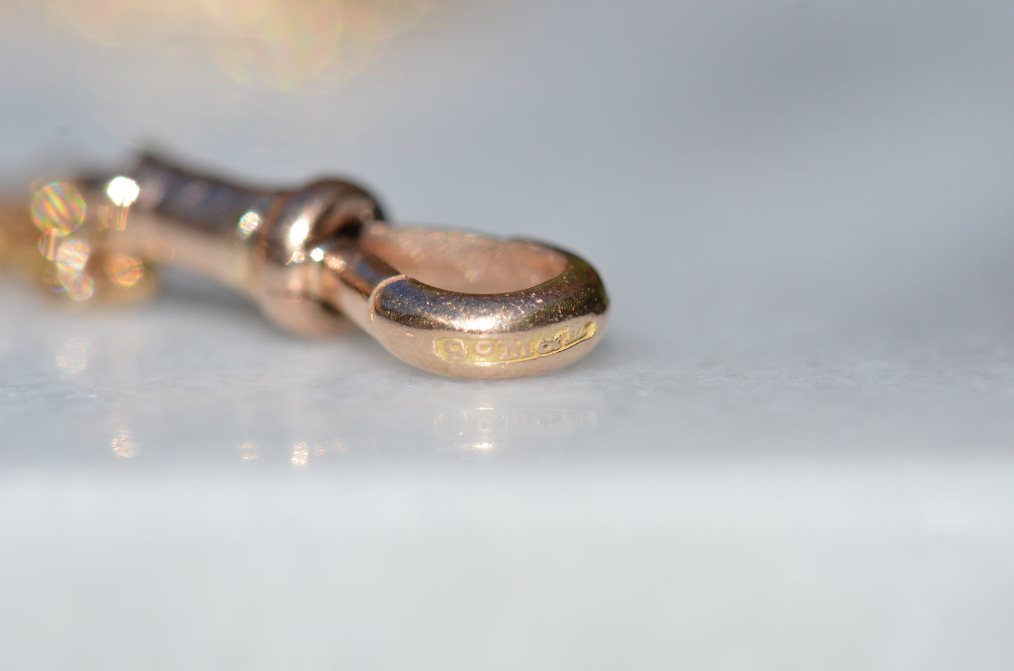 Worn British hallmarks on the outer edge of the dog clip clasp.