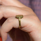 A closely cropped view of the ring on a Caucasian model's left pinky finger. The view is in profile to show the very low rise off the finger.