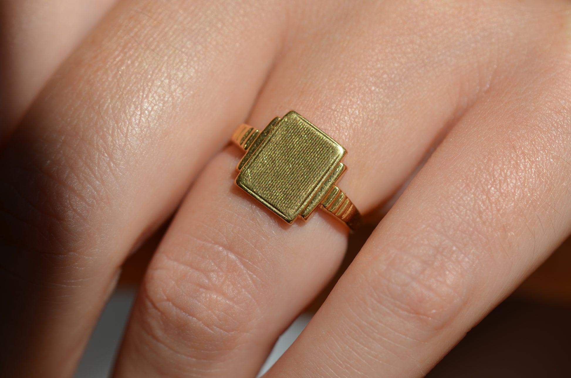 A medium-close view of the ring on the left ring finger of a Caucasian model. The ring is a little too tight on this finger.
