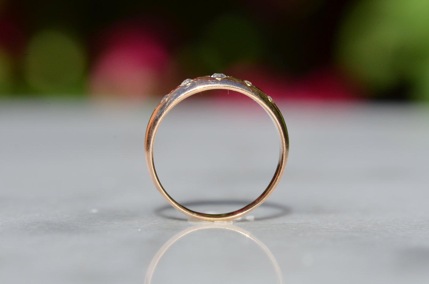 The ring is shown positioned upright and looking through the finger hole to highlight the low rise off the finger.