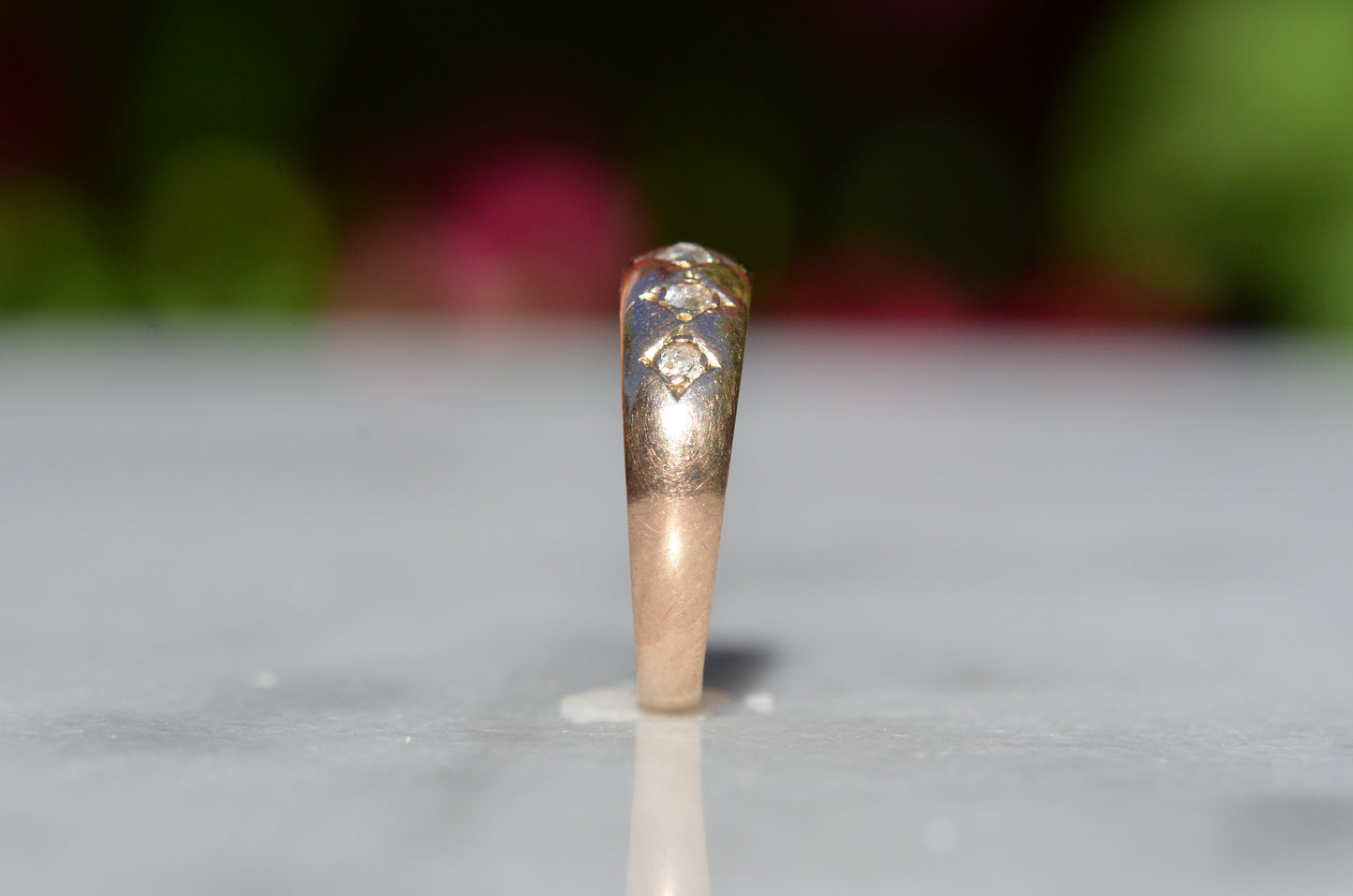 The ring is show positioned upright and from the side to highlight the tapered profile.