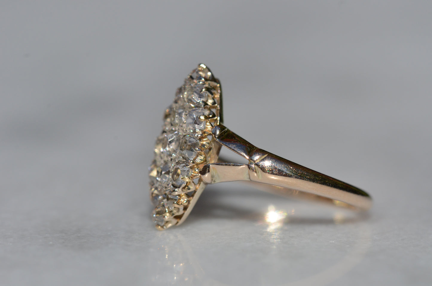 The closely cropped macro of this Victorian diamond navette ring is photographed turned to the left to highlight the split shoulder detail of the band, and a side view of the diamonds that highlights their tall crown facets.