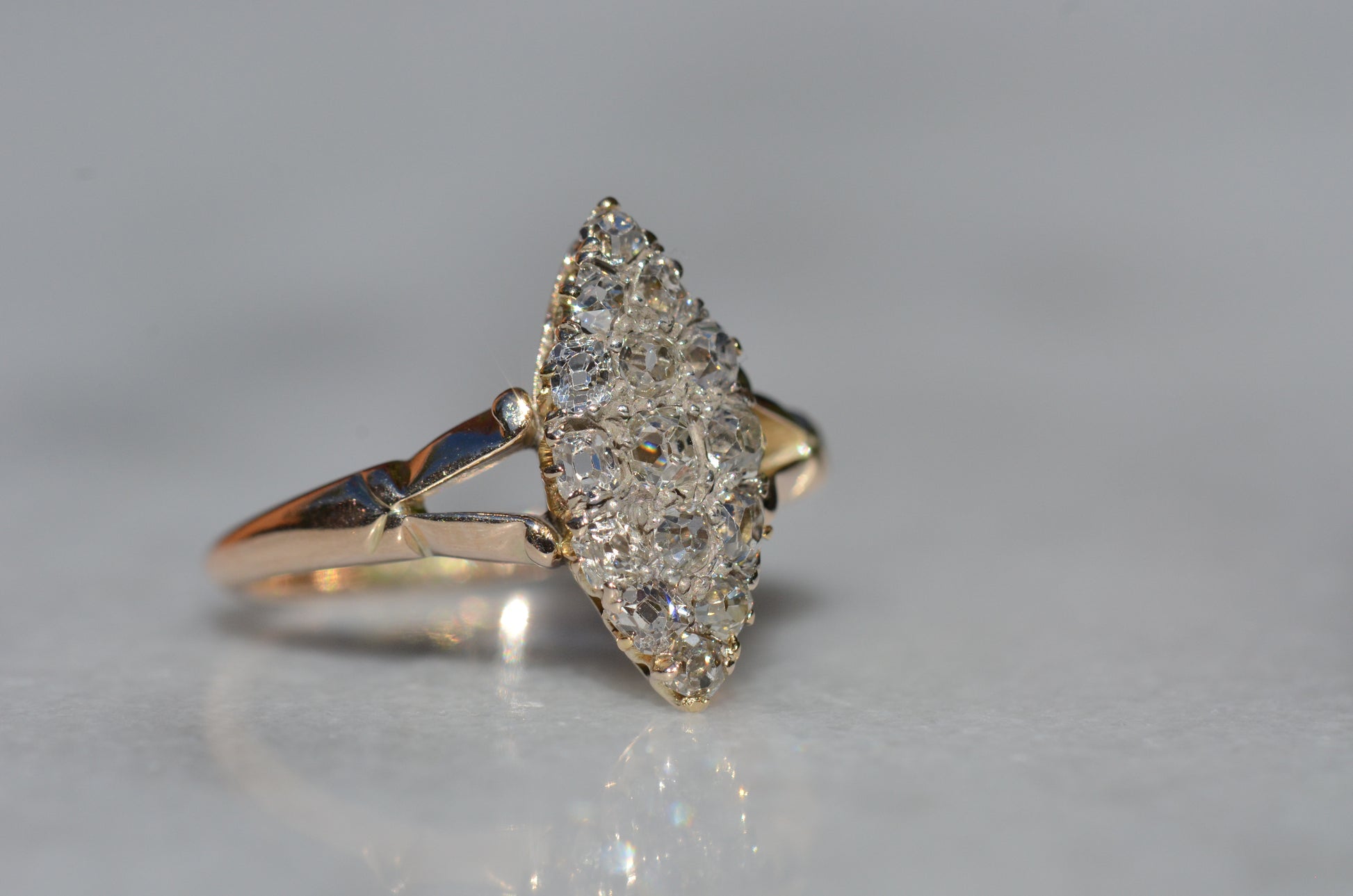 The closely cropped macro of this Victorian diamond navette ring is photographed turned slightly to the right to showcase the high rise of the crowns of each hand-cut diamond.