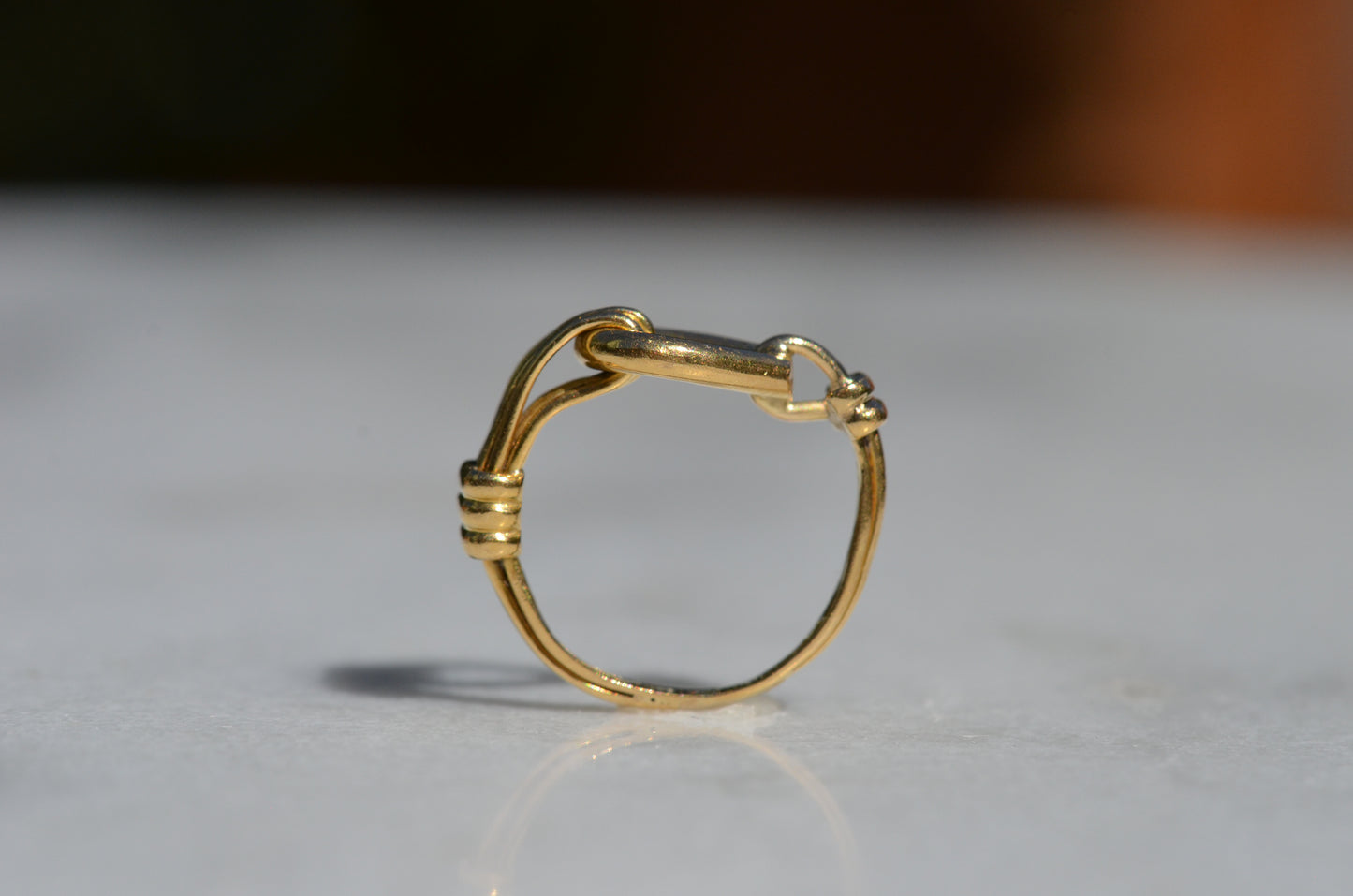 The ring is positioned upright and looking through the finger hole, further showcasing the asymmetric design and the flat top of the ring.