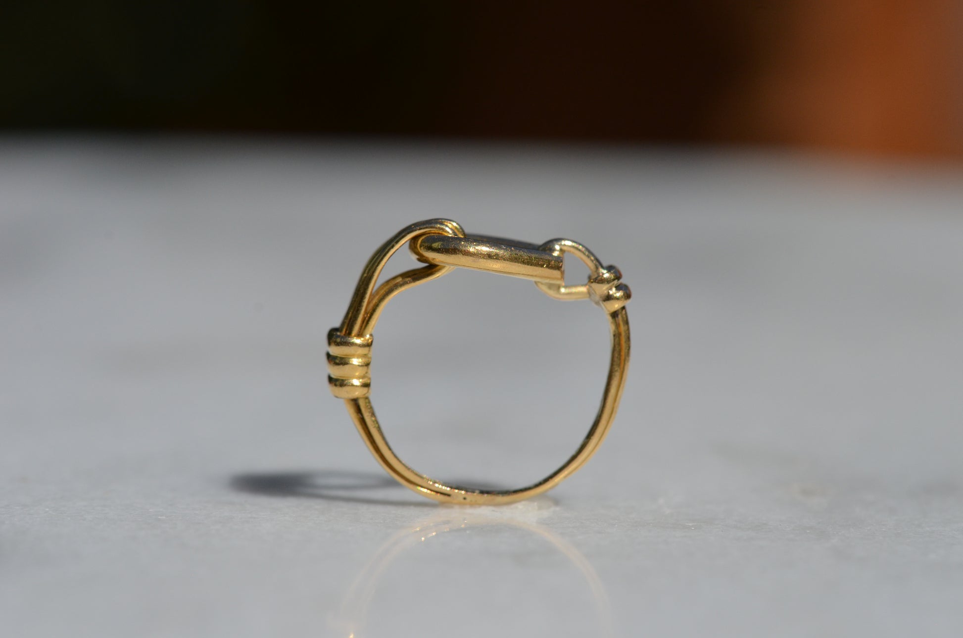 The ring is positioned upright and looking through the finger hole, further showcasing the asymmetric design and the flat top of the ring.