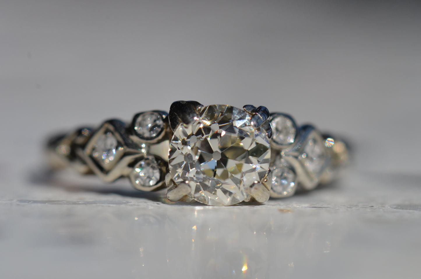 macro of ring head on. focal point is large, open culet and "kozibe effect," the ring of reflections from that culet visible only in antique cut diamonds.